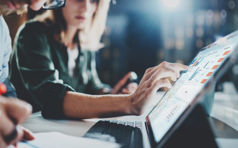 Woman pointing on digital tablet screen at night office .Horizontal.Blurred background.Flares