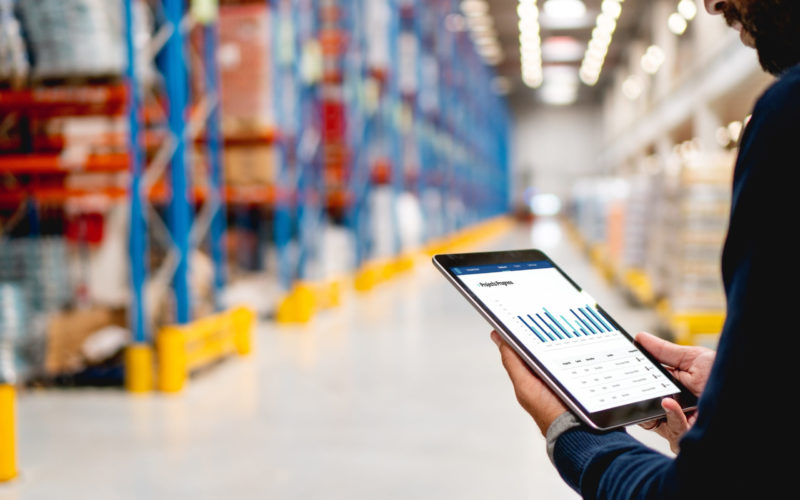 Manager in warehouse holding digital tablet