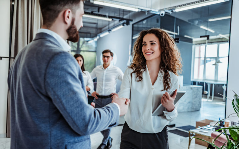 Man and woman are shaking hands in office. Collaborative teamwork.Business professionals