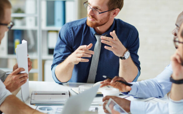 Young businessman listening to his colleague explanations and looking at him