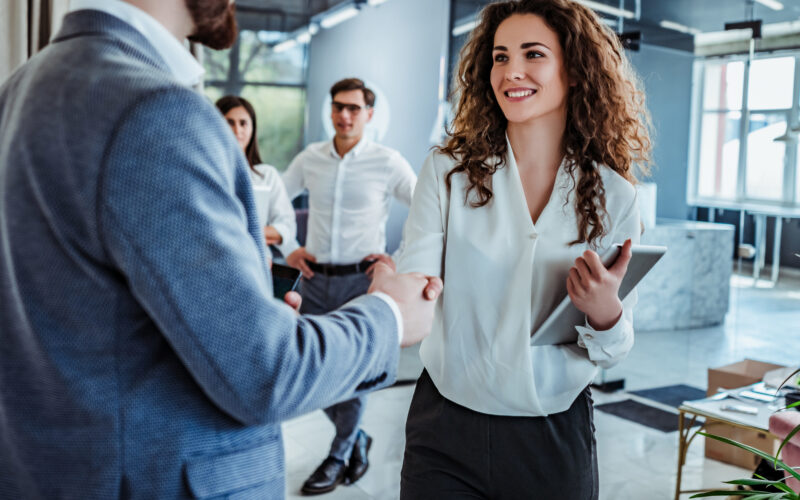 Man and woman are shaking hands in office. Collaborative teamwork.Business professionals