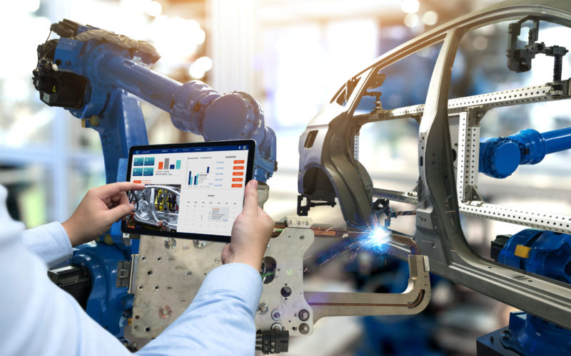 Engineer hand using tablet with machine real time monitoring system software. Automation robot arm machine in smart factory automotive industrial Industry 4th iot , digital manufacturing operation.