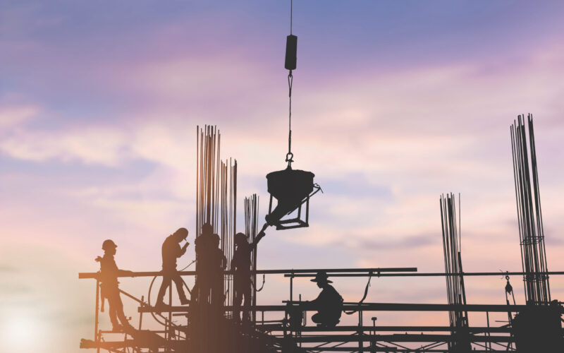 Silhouette engineer standing orders for construction crews to work safely on high ground over blurred natural background sunset pastel. heavy industry and safety at work concept.